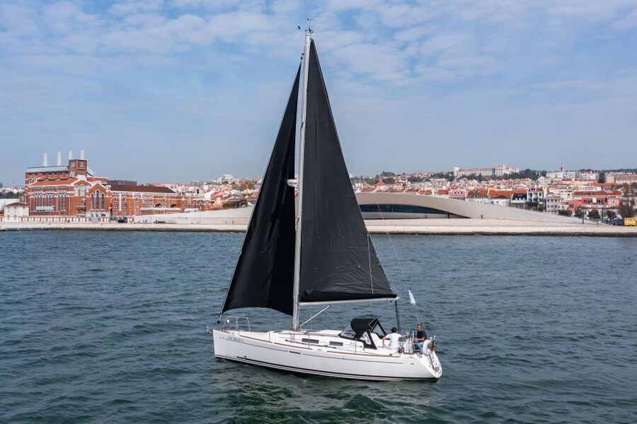 Lisbon: Private Sailboat Tour on the Tagus at Sunset - Passing under the bridge with Cristo Rei in view