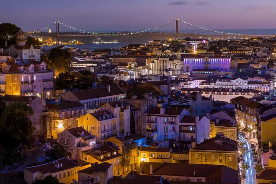 Lisbon: Private Sunset & Night Photo Walk - Alfama after dark: trams, glowing alleys, and illuminated buildings